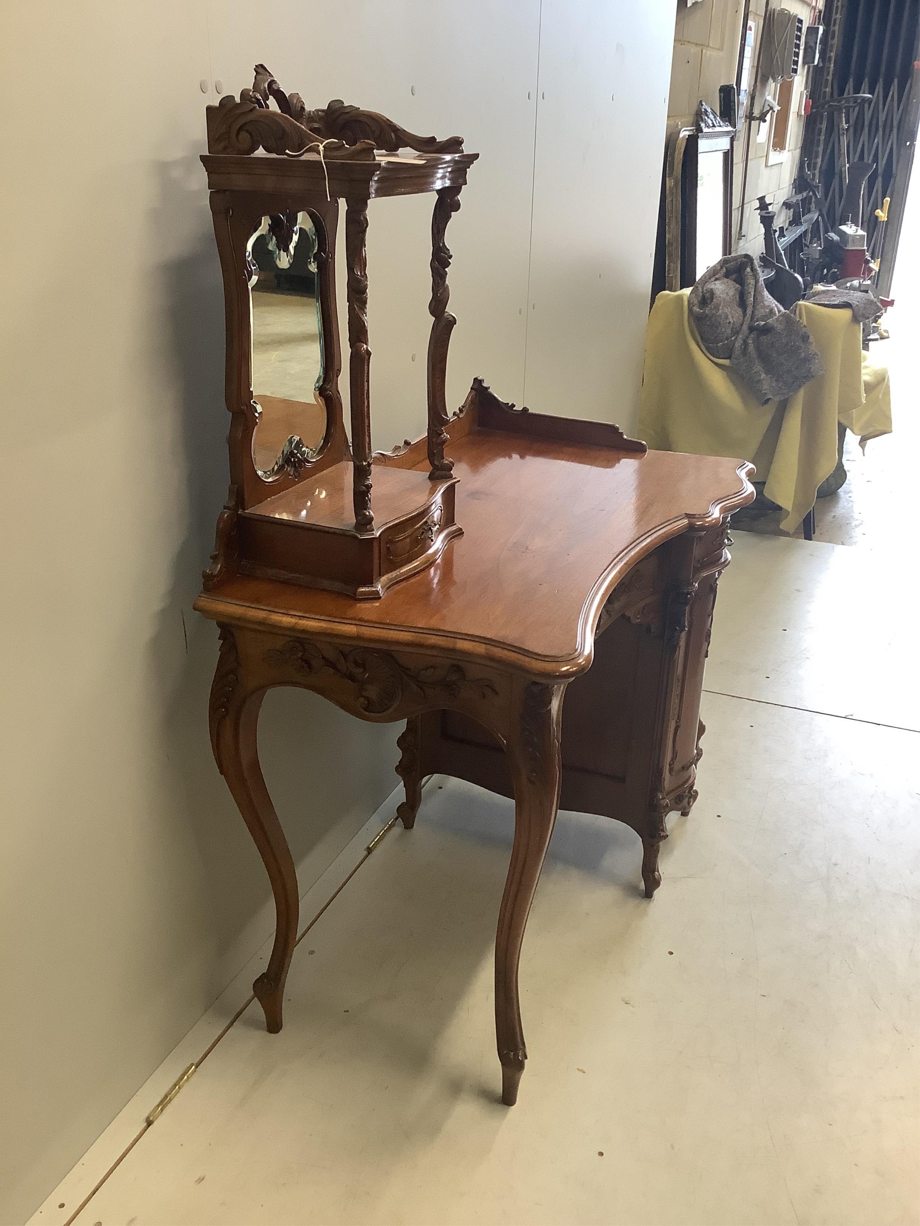 A Continental Art Nouveau carved walnut dressing table, width 92cm, depth 56cm, height 134cm. Condition - fair to good